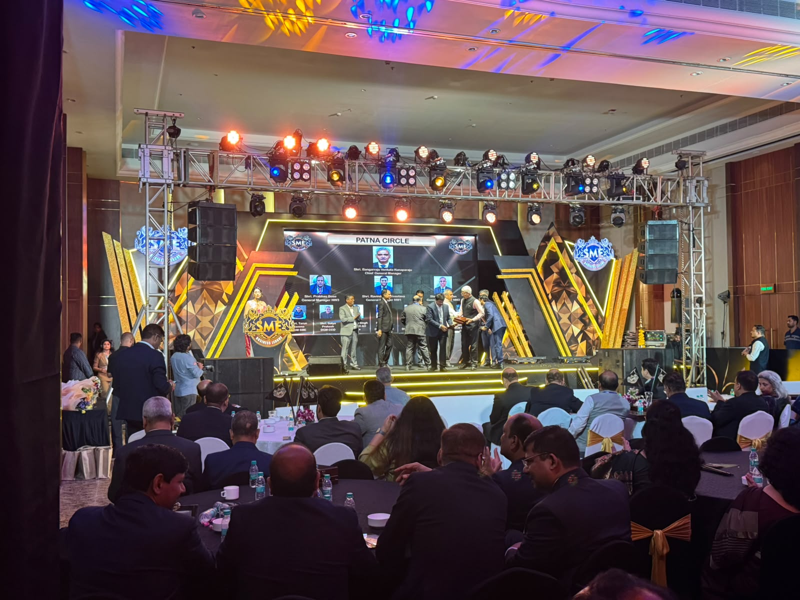 SME Business League awards night stage with Patna Circle presentation and geometric gold set design in a hotel ballroom