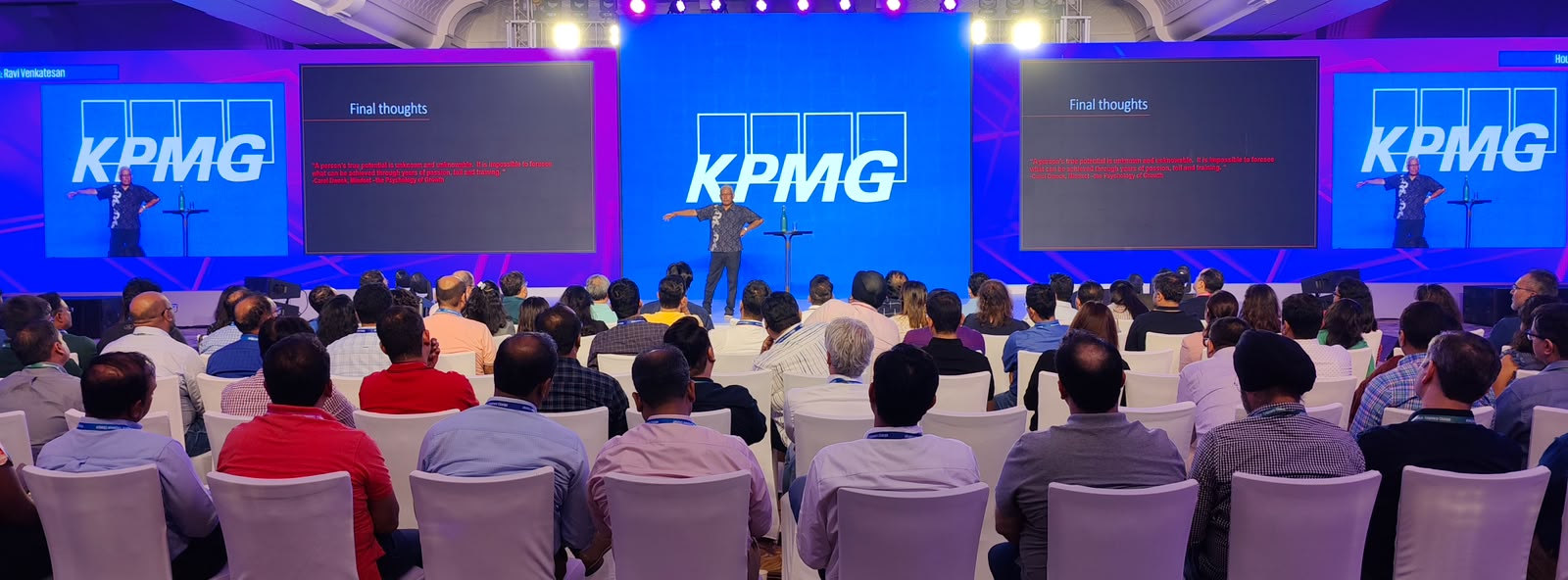 KPMG keynote by Ravi Venkatesan on stage with side LED walls and packed audience