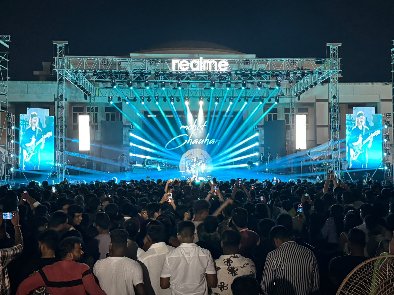 Realme Mohit Chauhan live concert with dense blue beam lighting, side LED walls and packed crowd