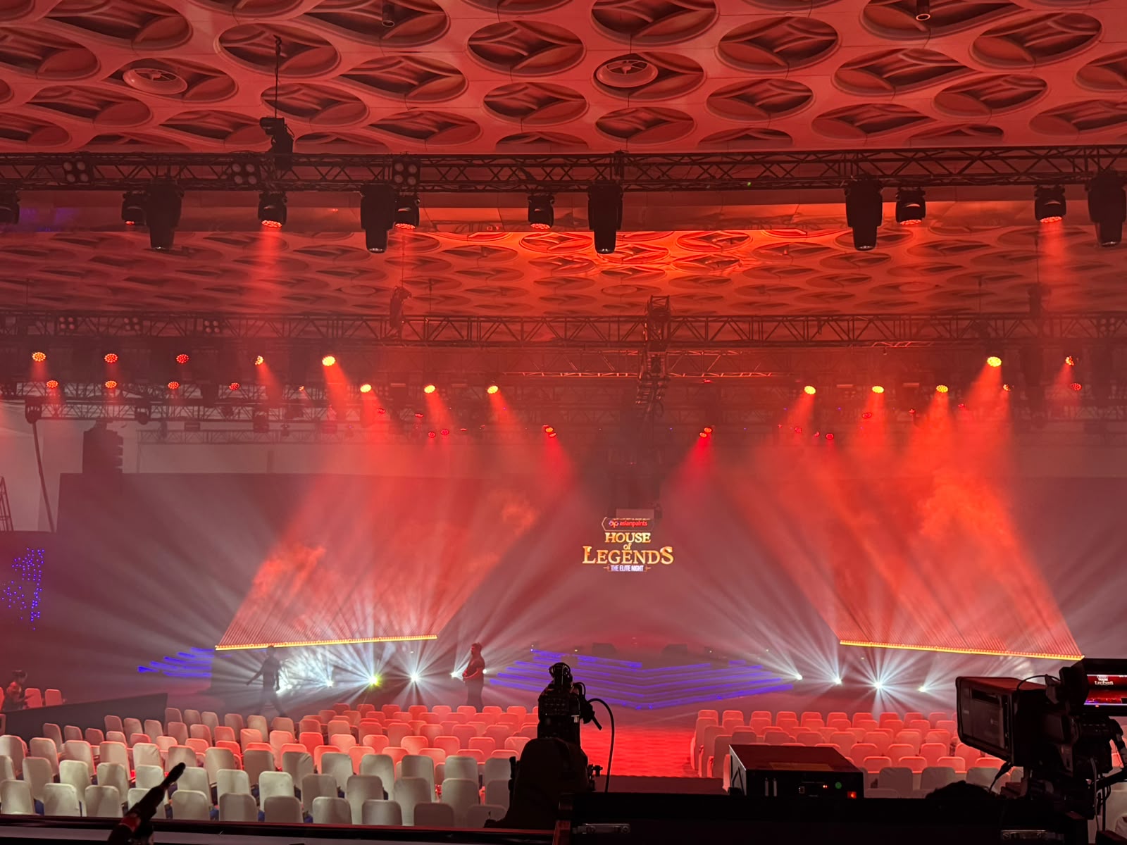 Asian Paints House of Legends stage bathed in red beam lighting with laser floor effects