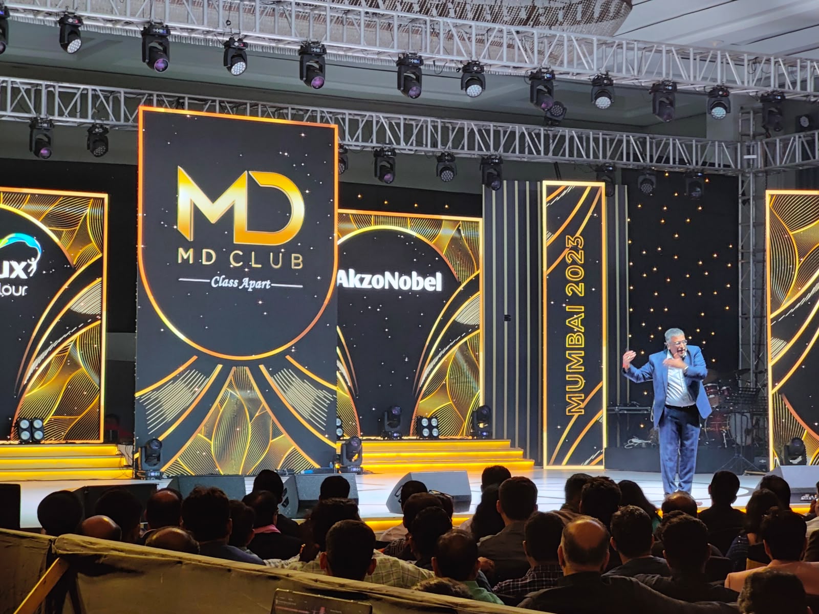 AkzoNobel MD Club Mumbai 2023 stage with MD Club Class Apart branding and a performer entertaining the seated audience