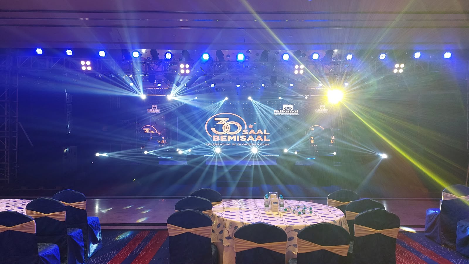 Nilkamal 30 Saal Bemisaal stage with dense beam lighting and celebration branding