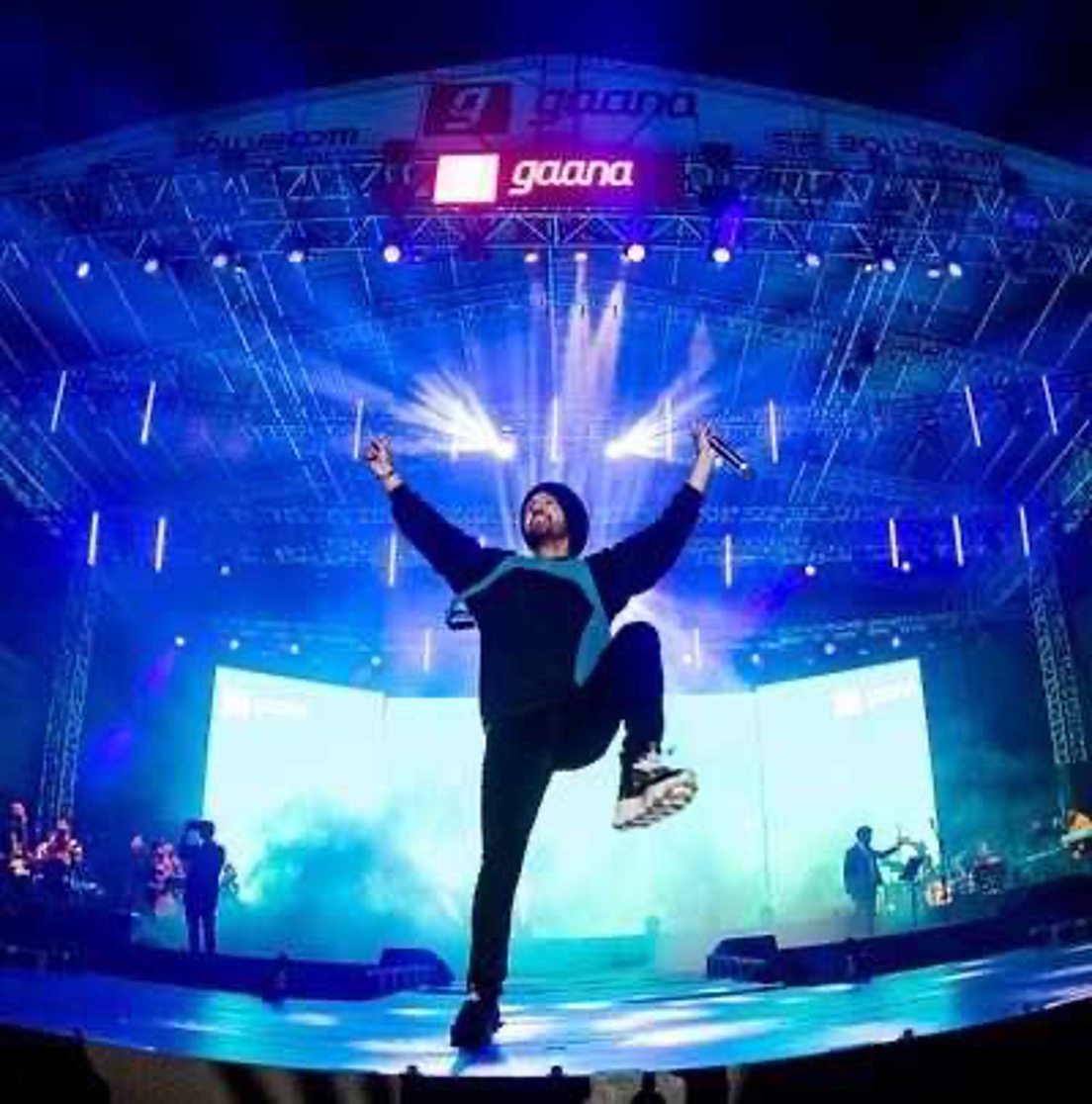 Artist performing at Gaana Live concert with blue stage lighting